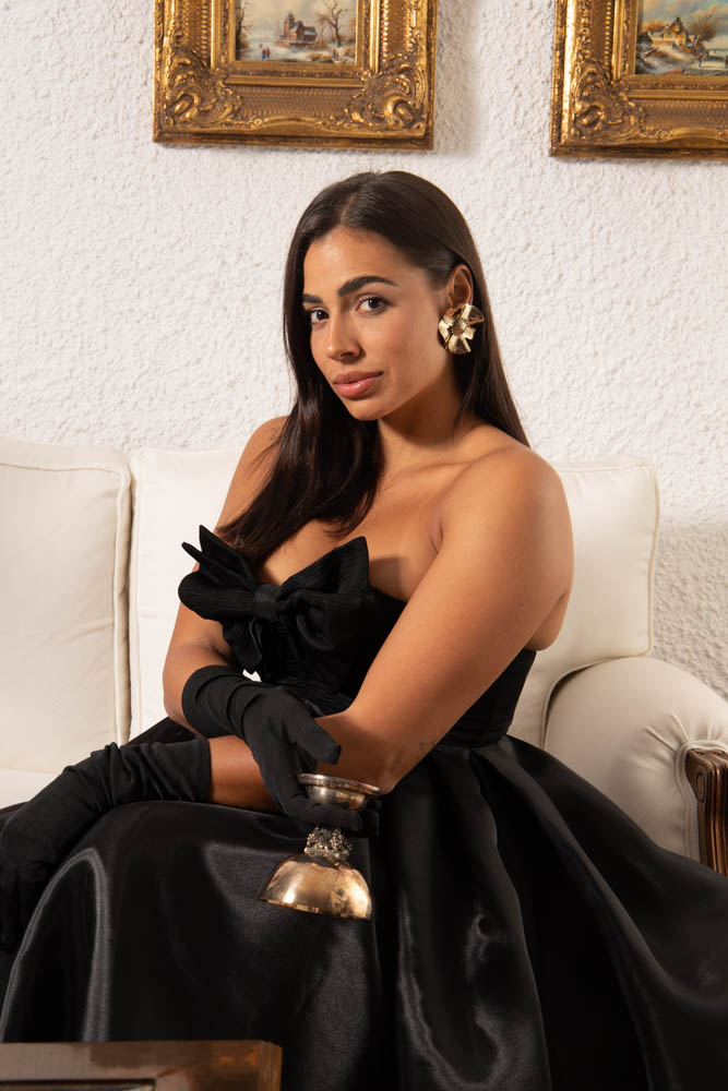 modelo con vestido negro de lluis mengual sujetando una copa de plata
